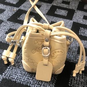Cream Drawstring Mini Bucket Bag with Embossed Motif